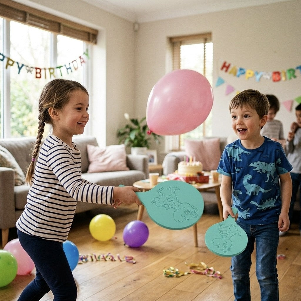Zwei Kinder spielen mit Schaumstoffschlägern und einem rosa Ballon. Spaß auf dem Kindergeburtstag.