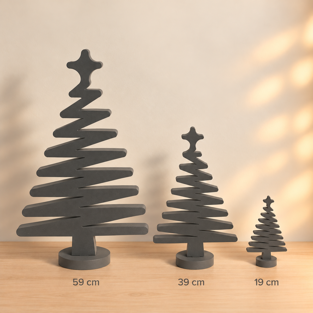 Minimalistische Deko Weihnachtsbäume aus PE Schaumstoff in Dunkelgrau mit Stern und rundem Standfuß in 59, 39 und 19 cm Höhe.
