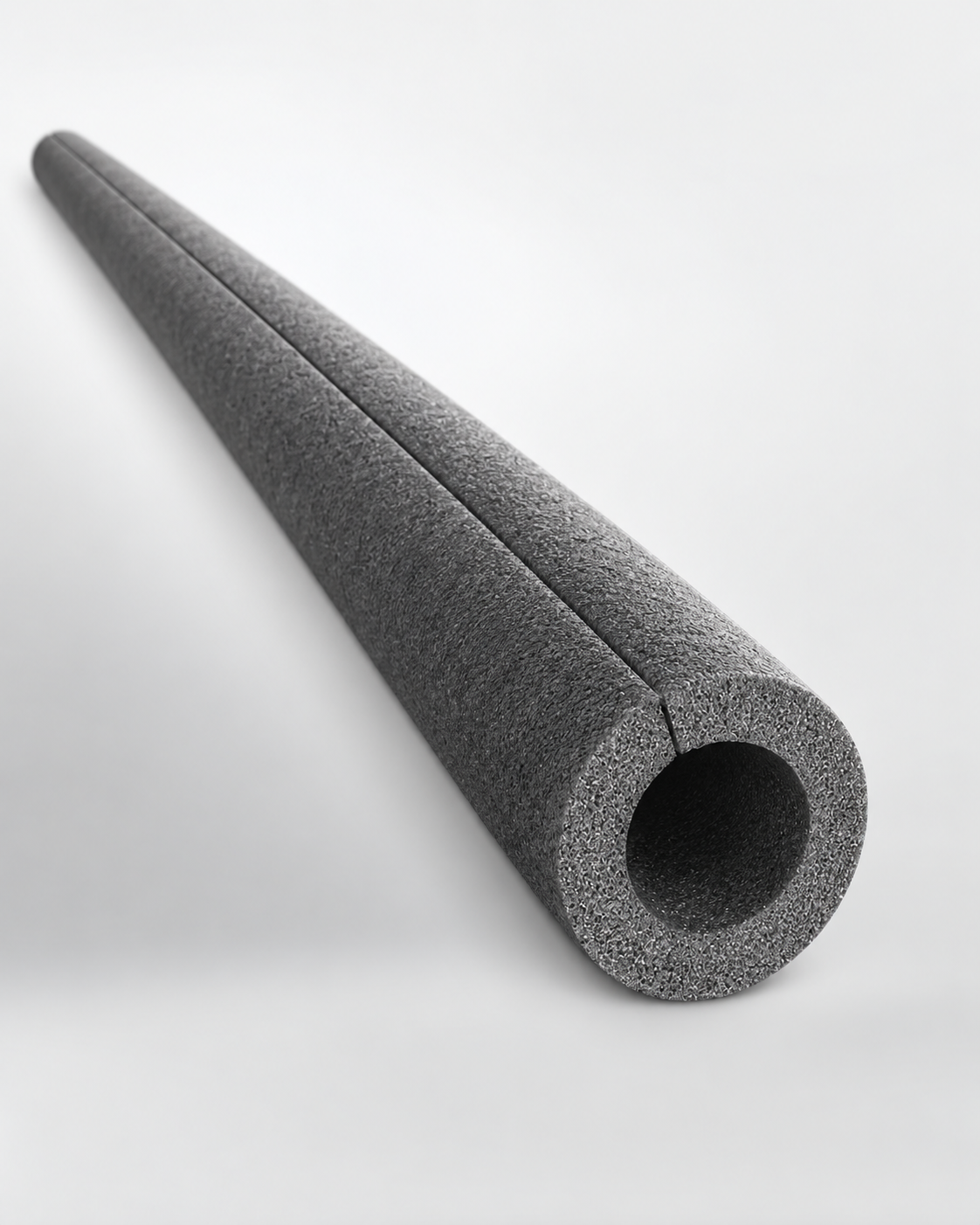 Graues NOMAPACK® O SLIT 22-9 Schutzprofil aus PE Schaumstoff mit sichtbarem Hohlraum und durchgehendem Längsschlitz vor hellem Hintergrund