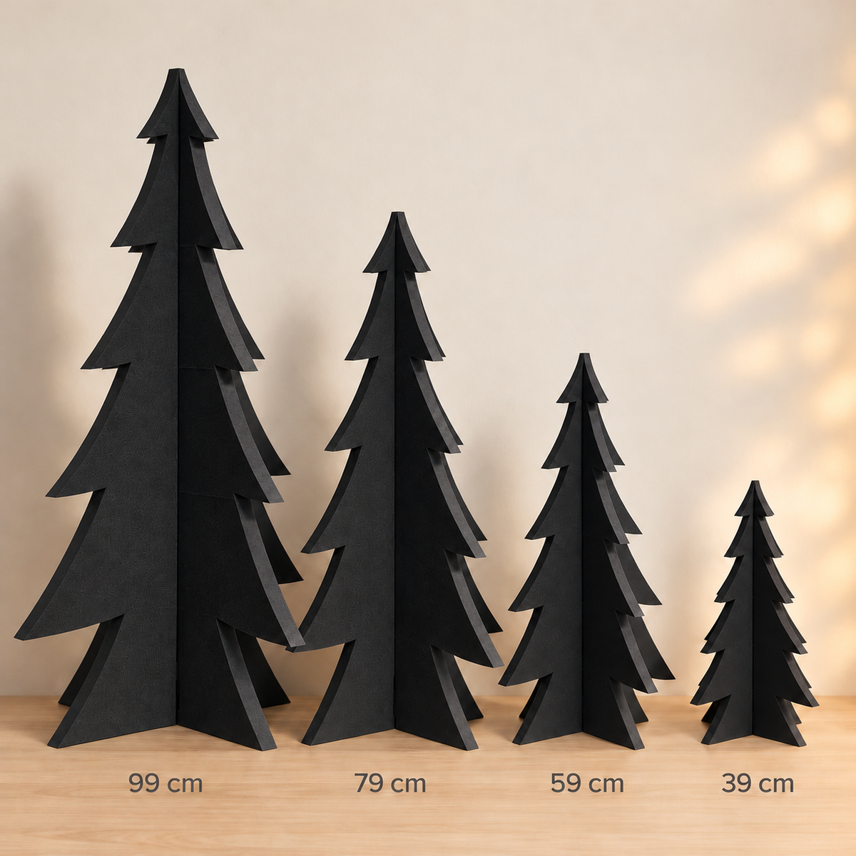 Vier schwarze Steckweihnachtsbäume aus PE-Schaumstoff in 39, 59, 79 und 99 cm Höhe im Größenvergleich